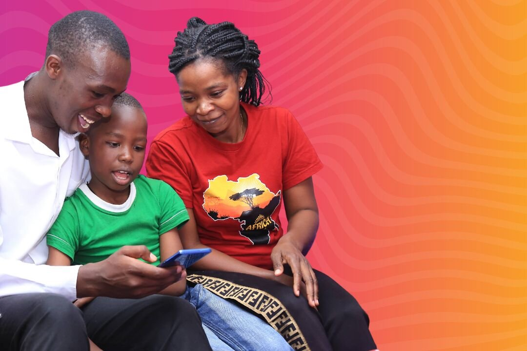 A family of three reads together on a mobile phone